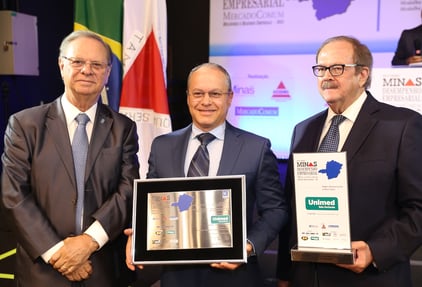 Frederico Peret, entre Cledorvino Belini e Carlos Alberto Teixeira, celebra a conquista dos troféus do Prêmio Minas Desempenho Empresarial, reconhecimento pela excelência e liderança da Unimed-BH no mercado mineiro